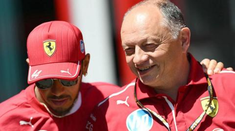 Ferrari driver Lewis Hamilton with his left arm around the shoulder of team boss Frederic Vasseur, who is smiling