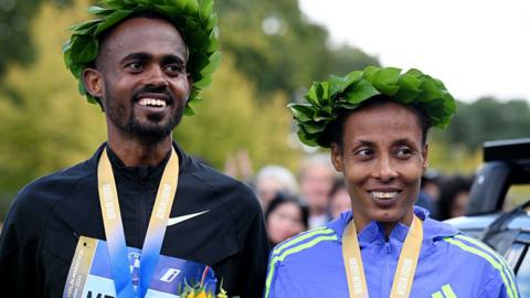 Ethiopians Milkesa Mengesha, who won the men's race, and Tigist Ketema, victor in the women's race, with their medals at the Berlin Marathon