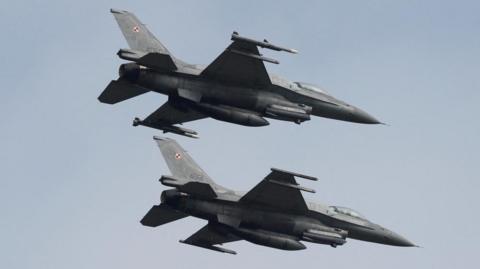 Two Polish F-16 fighter jets flying side by side