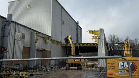 The exterior of the former government forensic and ballistics site, Fort Halstead near Sevenoaks, Kent. Two 'Cat' diggers can be seen preparing to demolish the site, which has fencing around it.