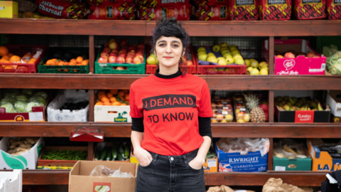 Aisha Zia in front of shelves with fruit 