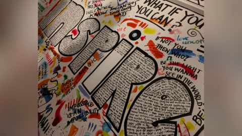 A large mural with the word inspire at it's centre.
