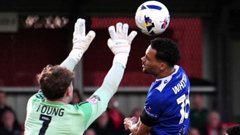 Salford City goalkeeper Matt Young and Bromley's Corey Whitely in action