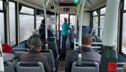 The view of passengers on a bus from the back