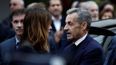 Nicolas Sarkozy looks at his wife Carla Bruni-Sarkozy before he goes to jail