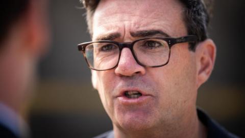 A close-up of Andy Burnham. He is wearing glasses. 
