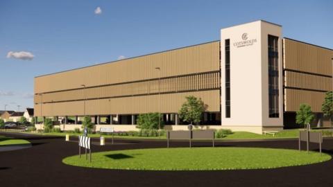 An artist's impression depicts what the car park would look like. With a wooden exterior it looms over the road outside.
