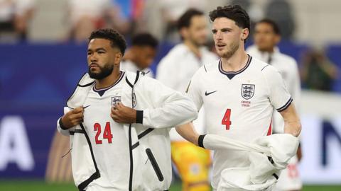  Reece James and Declan Rice of England prepare for a game by removing their warm-up tops.