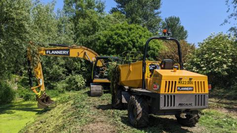 JCB used to clear weed from stream