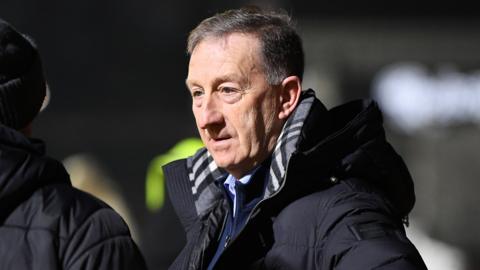 Huw Jenkins in a black coat at a Newport game
