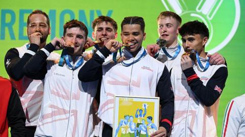 Great Britain's men biting their gold medals.