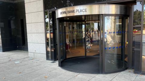 An automatic door that is ciurcular with the words Royal Bank Palace over the top of it.