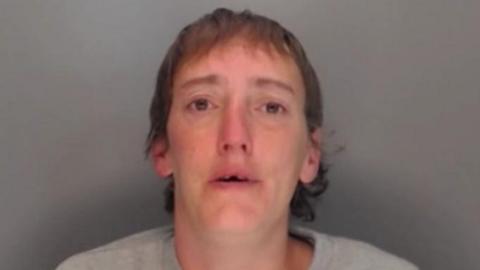 Mugshot of Hewitt. She has short brown hair and appears to be missing her two front teeth.