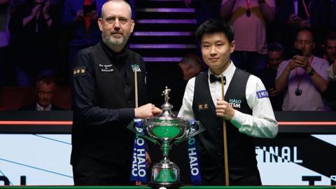 Mark Williams and Zhao Xintong posing with the World Championship trophy before the final