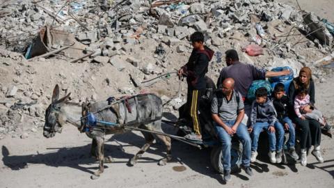 Palestinians make their way with belongings as they fled their homes