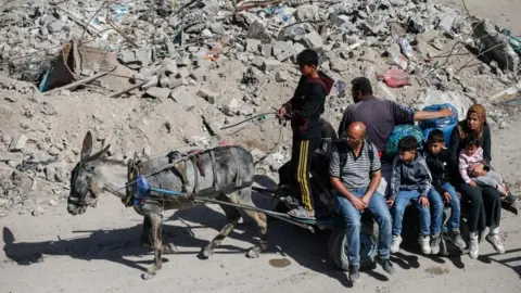 Palestinians make their way with belongings as they fled their homes