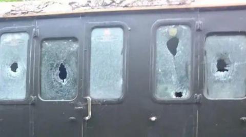 Five smashed windows on a carriage on the Lavender Line.