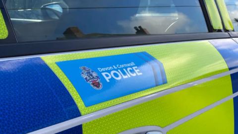 A close up of a Devon and Cornwall Police car. The logo is emblazoned across one of the doors.