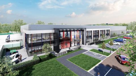 A CGI image of what the new Royal British Legion Industries factory and head office would look like once complete. The two-storey open-plan building has blue and red poles running top to bottom. The plans include disabled parking and some grass and trees. 