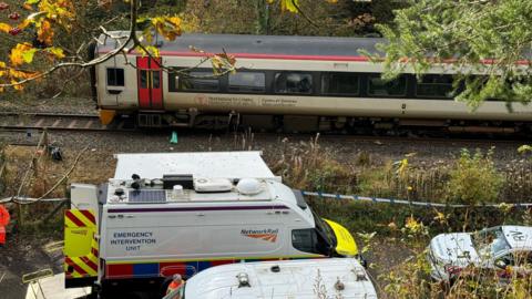 Emergency service vehicles near one of the trains involved in the collision in Powys