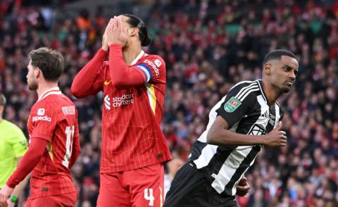 Alexander Isak in action for Newcastle United against Liverpool, running away from Virgil van Dijk, whose hands cover his own face