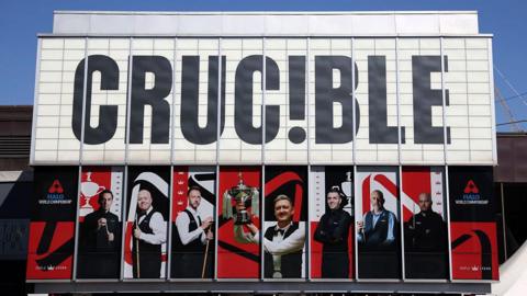 Sheffield's Crucible Theatre during the World Snooker Championship, featuring large pictures of players covering windows on the building