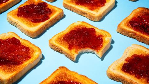 Slices of jam on toast lined up on a blue background