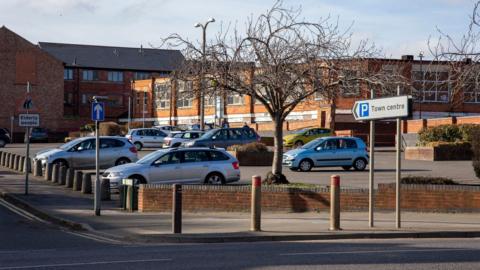 A car park in Oadby with a sign saying "town centre" and cars parked in the area