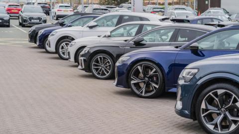 A row of Audi cars in a dealership lot