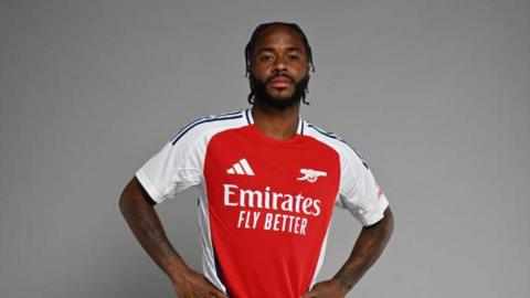 Raheem Sterling poses in an Arsenal shirt