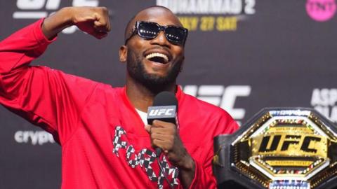 Leon Edwards smiles with his fist up at a news confernce