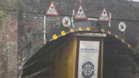 A lorry stuck underneath a railway bridge