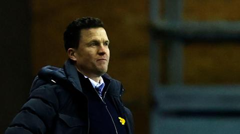 Wigan Athletic boss Gary Caldwell looks on