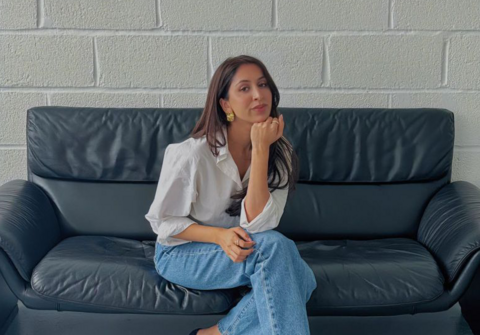 Minisha sat on a couch.