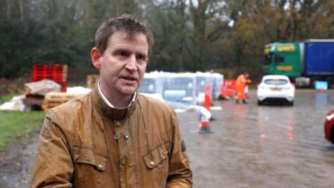 A man in a brown jacket. 
