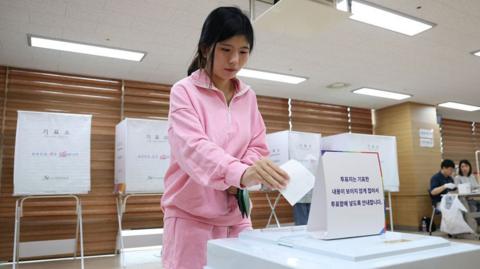 Woman wearing pink casts vote in South Korea