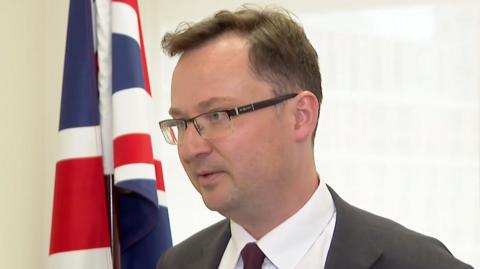 Alex Norris stands in front of a Union flag