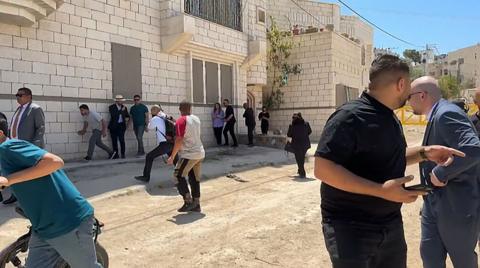 Members of a diplomatic delegation reacting after shots were fired as they gathered at an entrance Jenin camp, some apopear to be running away and others looking behind them 