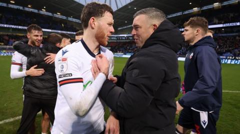 Bolton boss Steven Schumacher celebrates with Gethin Jones after their 4-3 win over Crawley.