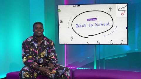 Nitro in the Newsround studio next to a big screen. 
