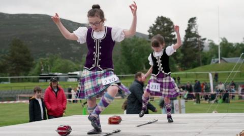 two girls dancing around swords