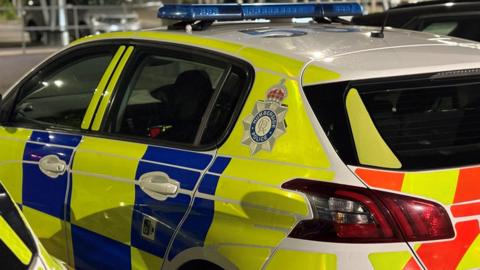 A file image of a Humberside Police patrol car. The side of the vehicle, which is covered in fluorescent yellow and blue stickers, is visible along with a large Humberside Police logo.
