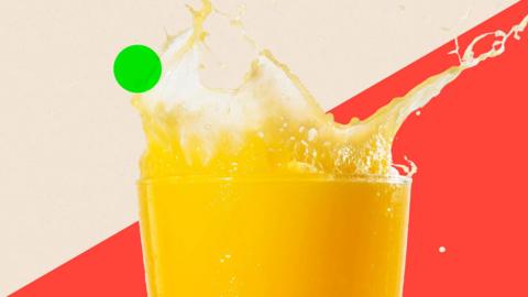 A glass of orange juice with a splash