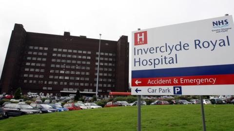 A view from outside of Inverclyde Royal Hospital, with a large sign saying the hospital's name.