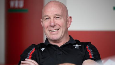 Huw Bevan smiling in Welsh Rugby Union-branded shirt