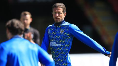 AFC Wimbledon player Sam Hutchinson looks on 
