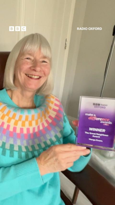 A woman holds an award.