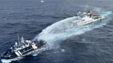 The China Coast Guard uses water canon on a Philippine vessel on patrol in disputed waters of the South China Sea on Wednesday.