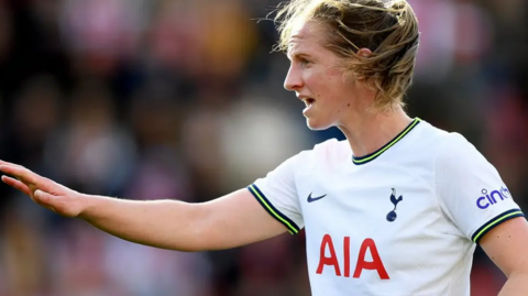 Kerys Harrop is in an England kit during a game. She has brown hair which is tied back.