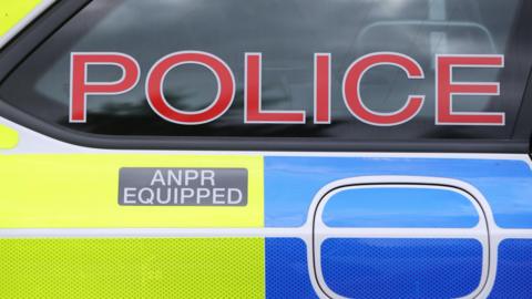 A police car with 'Police' written in red letters